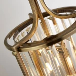 Lampa wisząca Victoria 2xE14 w antycznym mosiądzu, z okrągłą metalową oprawą i przezroczystymi kryształami. Zdjęcie pokazuje ją z góry, uwydatniając detale konstrukcji oraz blask emitowany przez umieszczone wewnątrz źródła światła.