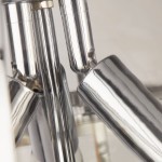 Lampa wisząca Coronet 3xE14 w chromowanym wykończeniu. Widać refleksyjne, błyszczące elementy metalowe oraz przezroczyste detale. Ujęcie z bliska ukazuje fakturę i kształt lampy.