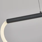 Lampa wisząca Meleca w kolorze czarnym, z pilotem. Konstrukcja z metalowym, matowym uchwytem oraz białym, zakrzywionym kloszem LED. Produkt zamontowany na cienkim, stalowym przewodzie. Tło jasnoszare, podkreślające elegancję lampy.