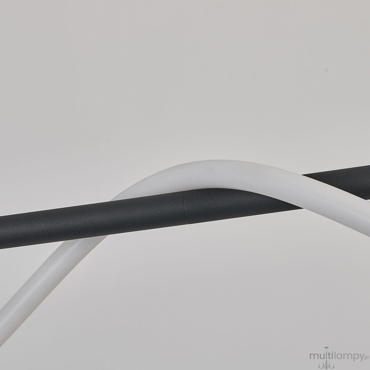 Czarna lampa wisząca Meleca z pilotem, wykonana z materiałów w matowym wykończeniu. Widoczne są dwa kable: czarny i biały, ułożone w formie skrętu. Lampa przeznaczona do oświetlenia wnętrz, z pojedynczym źródłem światła LED 36W.
