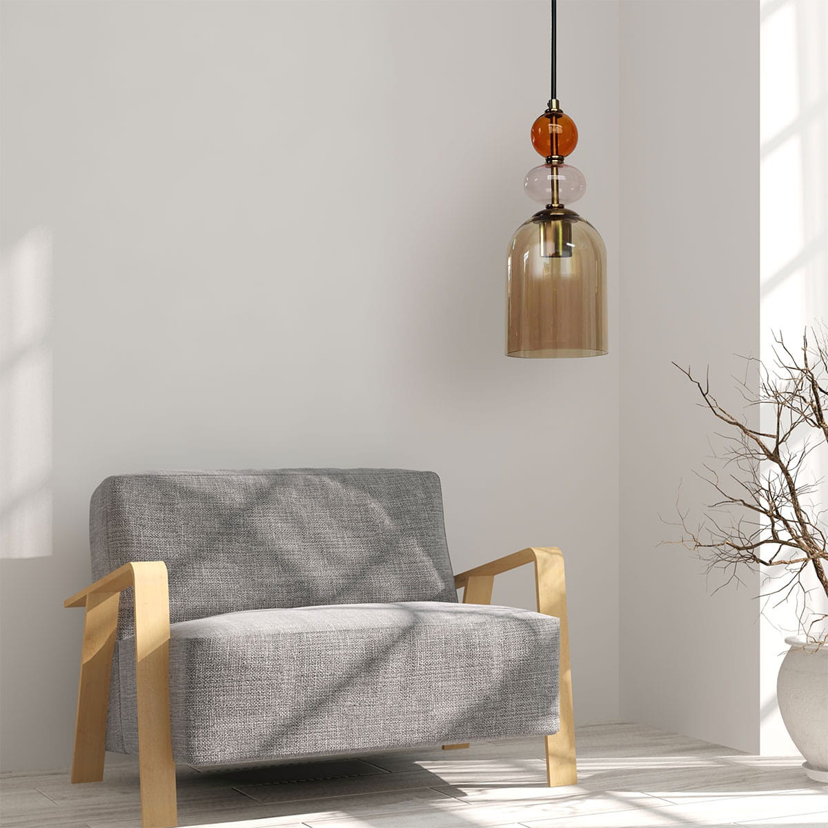 Lampa wisząca Tropea 1xE27 w kolorze czarnym i bursztynowym, z przezroczystym kloszem. Zawieszona na czarnym przewodzie, z dekoracyjnymi elementami w kolorze bursztynowym i różowym. Umieszczona nad szaro-beżową sofą w jasnym wnętrzu.