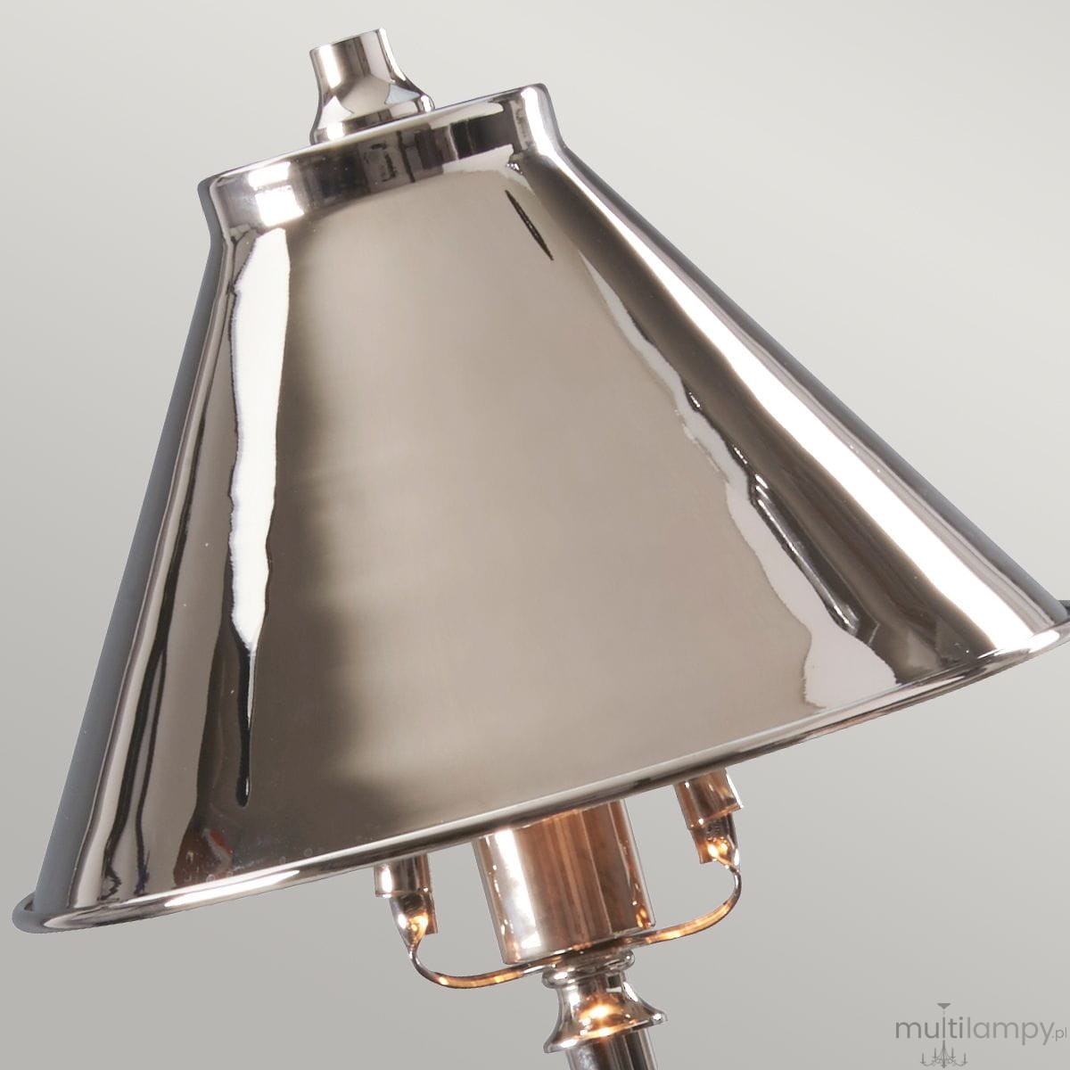 Lampka stołowa Provance 1xE14 w kolorze niklowym. Klosz o stożkowym kształcie, błyszcząca powierzchnia. Widoczne gniazdo na żarówkę E14 oraz dekoracyjny element przy podstawie. Ujęcie z góry, skupione na detalu klosza.