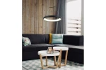 Lampa wisząca Thea D40 w kolorze czarnym, z okrągłym kloszem LED o mocy 24W, zawieszona nad białymi stolikami kawowymi. W tle ciemna sofa z poduszką w kolorze turkusowym i żółtym oraz drewniana ściana.