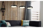 Lampa wisząca Thea 3xLED/36W w kolorze czarnym, z okrągłym kloszem, zawieszona na metalowych linkach. Widoczne w tle drewniane ściany i szary narożnik z poduszkami w różnych kolorach.