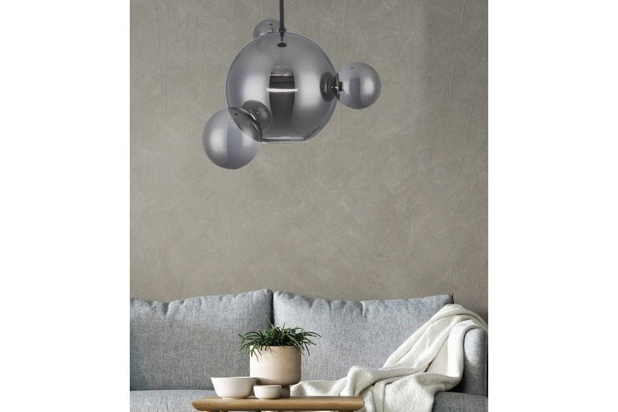 Lampa wisząca Multiverse 1xLED/10W w kolorze czarnym, o nowoczesnym designie. Kształt kulisty z przezroczystymi elementami, zawieszona nad szarym sofą w minimalistycznym wnętrzu. Widoczne detale konstrukcyjne i mocowanie.