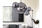 Lampa wisząca Multiverse w kolorze czarnym, z pojedynczym źródłem LED o mocy 10W. Okrągła, szklana konstrukcja z dekoracyjnymi kulami w różnych rozmiarach. Zawieszona w nowoczesnym wnętrzu nad szaro-skalnym obrazem i kanapą.