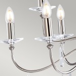 Lampa wisząca Finsbury Park z niklowanym wykończeniem, z sześcioma gniazdami E14. Widać eleganckie, przezroczyste podstawki oraz lekko zaokrąglone klosze w kształcie świec. Zawiera również kryształowe detale.
