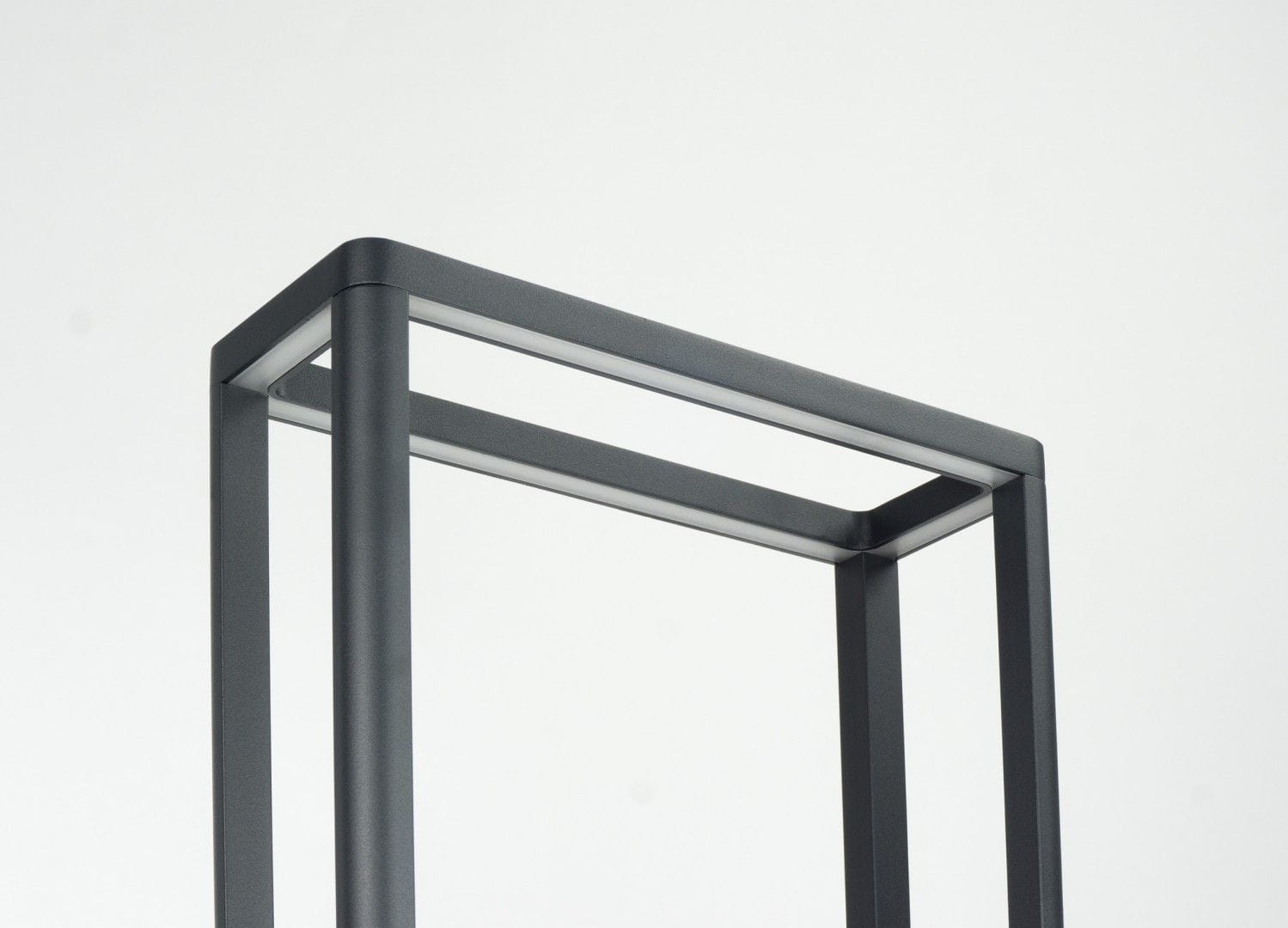 Lampa stojąca Arma H50 w ciemnym popiele, wykonana z metalu, z prostokątną podstawą i minimalistycznym designem. Widoczne górne ramy lampy, z miejscem na jedną żarówkę LED 9W. Ujęcie z góry, ukazujące detal konstrukcji.