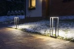 Lampa stojąca Arma H50 w ciemnym popiele, z jedną żarówką LED o mocy 9W. Ujęcie z boku, pokazujące lampę w oświetlonym otoczeniu, na tle trawnika pokrytego śniegiem oraz kostki brukowej.