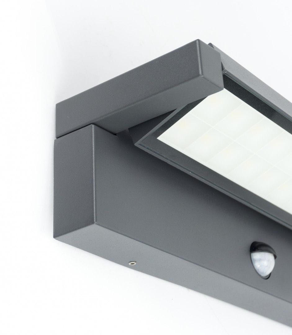 Kinkiet elewacyjny kierunkowy LED 27W w ciemnoszarym kolorze z czujnikiem ruchu. Posiada prostokątną, matową osłonę z białymi panelami oraz widoczny czujnik ruchu. Zamontowany w pozycji poziomej, idealny do oświetlenia zewnętrznego.