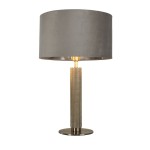 Lampa stołowa London w satynowym srebrze z szarym abażurem. Posiada okrągłą podstawę, cylindryczny korpus z teksturowanej powierzchni oraz metalowe detale. Ujęcie frontalne, lampa stoi na płaskiej powierzchni.