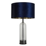 Lampa stołowa Oxford z czarną podstawą i granatowym kloszem z weluru. Klosz ma złote wnętrze, a podstawa jest przezroczysta, z okrągłym, czarnym, marmurowym detalem. Produkt ustawiony w pozycji stojącej, widok frontalny.