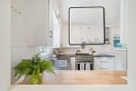 Lampa wisząca Anaya 1xLED/24W w kolorze czarnym, o kwadratowym kształcie, zawieszona nad blatem kuchennym. Widoczna w nowoczesnym wnętrzu z białymi szafkami i drewnianym blatem, w otoczeniu rośliny doniczkowej.