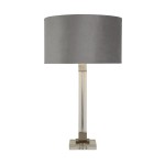 Lampa stołowa Scarborough z szarym, materiałowym abażurem oraz podstawą z satynowego niklu. Stojąca, z przezroczystym elementem w dolnej części i kwadratową podstawą. Prosta, elegancka forma, idealna do nowoczesnych wnętrz.