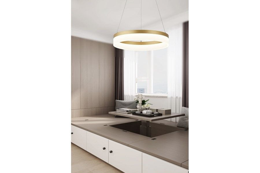 Lampa wisząca Cornelia 1xLED/24W w kolorze złotym, okrągła, zawieszona w jasnym wnętrzu z drewnianymi panelami. Widoczna w kontekście nowoczesnego salonu z minimalistycznym stołem i dekoracjami na blacie.