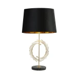 Lampa stołowa Rye z metalowym, złotym stelażem i czarnym, matowym kloszem. Stojąca na okrągłej, czarnej podstawie z marmuru, z dekoracyjnym, spiralnym detalem w centralnej części. Idealna do nowoczesnych wnętrz.