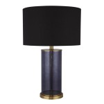 Lampa stołowa Liberty z mosiężnymi detalami i czarnym abażurem. Cylindryczna podstawa w kolorze szarym, wykończona metalowym pierścieniem. Ujęcie frontalne, produkt stoi na płaskiej powierzchni, bez dodatkowych akcesoriów.