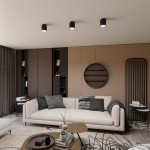 Nano lampa sufitowa 1xGU10/AR 111 w kolorze czarnym, zamontowana w trzech punktach na suficie. Lampa ma cylindryczny kształt i minimalistyczny design. Tło w odcieniach beżu z sofą, stolikami i dekoracjami tworzy nowoczesną aranżację wnętrza.