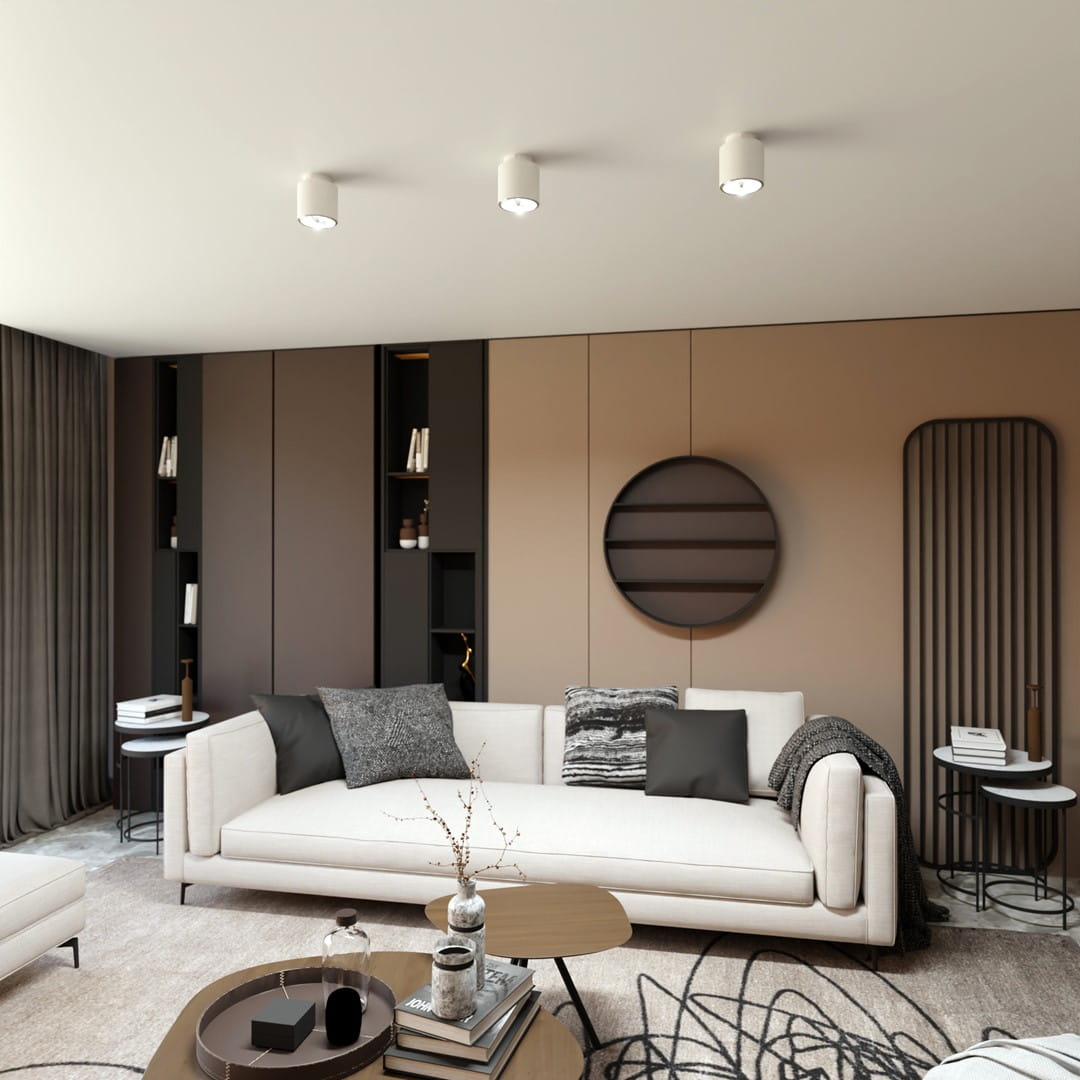 Nano lampa sufitowa 1xGU10/AR 111 w kolorze białym, zamontowana na suficie, z okrągłym kloszem. W tle nowoczesny salon z jasną kanapą, stołem kawowym i półkami ściennymi, w neutralnej kolorystyce.
