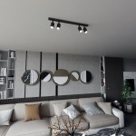 Czarna lampa sufitowa Flash z czterema reflektorami GU10, zamontowana na suficie. Reflektory skierowane w dół, w nowoczesnym wnętrzu z szaro-białymi dekoracjami na ścianie oraz sofą w odcieniach beżu. Tło w jasnych kolorach, minimalistyczne.