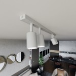 Lampa sufitowa Flash z 4 punktami świetlnymi GU10 w kolorze białym, zamontowana na prostokątnej listwie. Ujęcie z góry, pokazujące trzy lampy skierowane w różne strony. Tło z minimalistycznym wystrojem wnętrza.