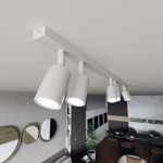 Biała sufitowa lampa typu spot z sześcioma oprawami GU10, zamontowana na prostokątnej listwie. Lampa wisi pod sufitem, oświetlając przestrzeń. Widoczne detale to gładkie, cylindryczne klosze i minimalistyczny design.
