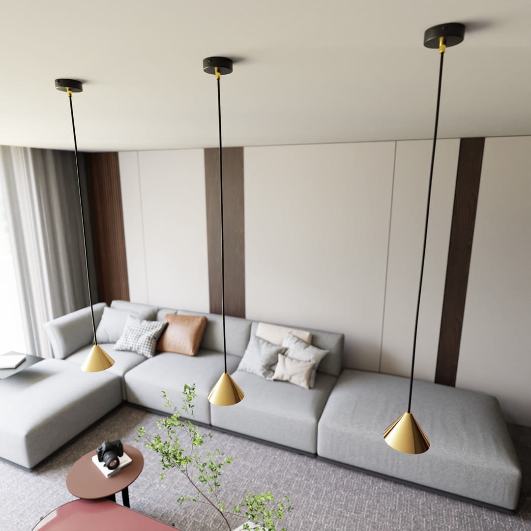 Lampa wisząca Elit 1xGX53 w kolorze czarnym i złotym, z minimalistycznym, stożkowym kloszem. Zawieszona na długim, czarnym przewodzie. Widoczna w nowoczesnym wnętrzu z szarym sofą i dekoracyjnymi poduszkami.