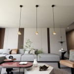 Lampa wisząca Elit 1xGX53 w kolorze czarnym i złotym, w kształcie stożka, zawieszona na długich przewodach. Widoczne trzy lampy w nowoczesnym wnętrzu z szarym sofą i stołem kawowym. Tło jasne, minimalistyczne.
