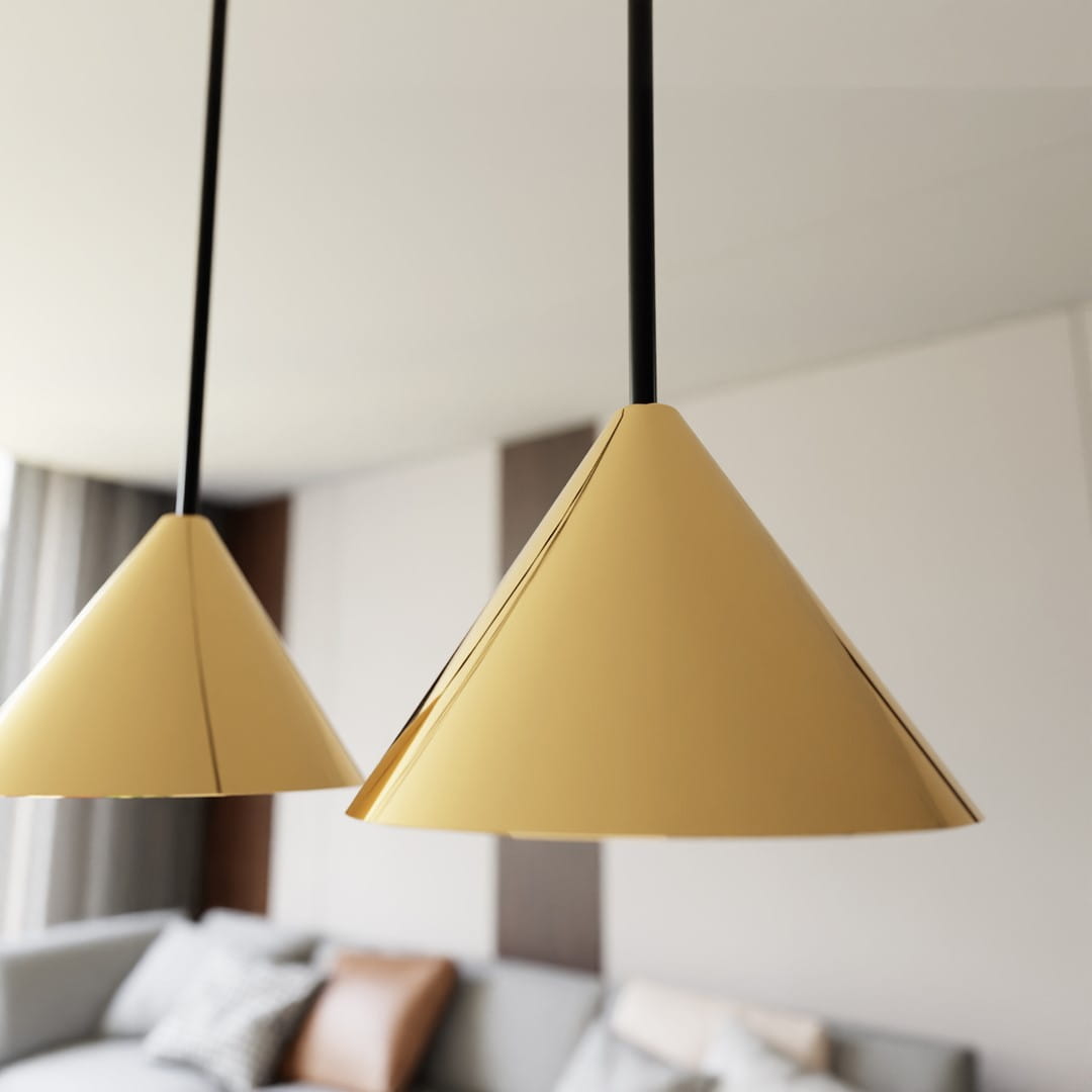 Lampa wisząca Elit 4xGX53 w kolorze czarnym i złotym. Widok w zbliżeniu na dwa złote klosze o stożkowym kształcie, zawieszone na cienkich czarnych linkach. Tło neutralne, z szarym sofą i poduszkami.