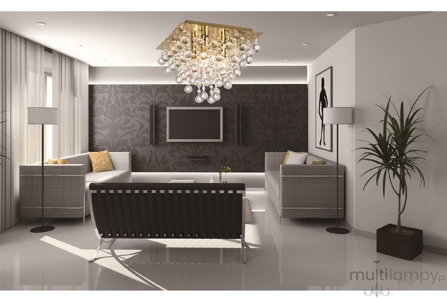 Lampa sufitowa Lancaster Crystal w kolorze złotym, z trzema miejscami na żarówki E14, zawieszona w nowoczesnym wnętrzu. W tle jasne ściany, ciemna tapeta oraz meble w odcieniach szarości i czerni.