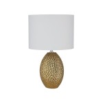 Lampa stołowa Nadine z podstawą w złotym kolorze o teksturowanej powierzchni i kremowym, okrągłym abażurem. Ujęcie frontalne, produkt stojący, idealny do wnętrz nowoczesnych. Wysokość lampy nieokreślona.