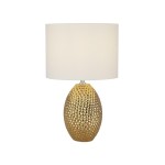 Lampa stołowa Nadine z materiałowym kloszem w kremowym kolorze, umieszczona na złotej, teksturowanej podstawie o kształcie jajowatym. Ujęcie frontalne, produkt stojący na białym tle.