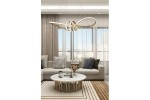 Lampa wisząca Canbera z jedną żarówką LED 40W w kolorze złotym. Ma nowoczesny, organiczny kształt, zawieszona nad okrągłym stołem w jasnym wnętrzu salonu z szarymi zasłonami i sofą. W tle widoczne dekoracyjne poduszki i stół kawowy.