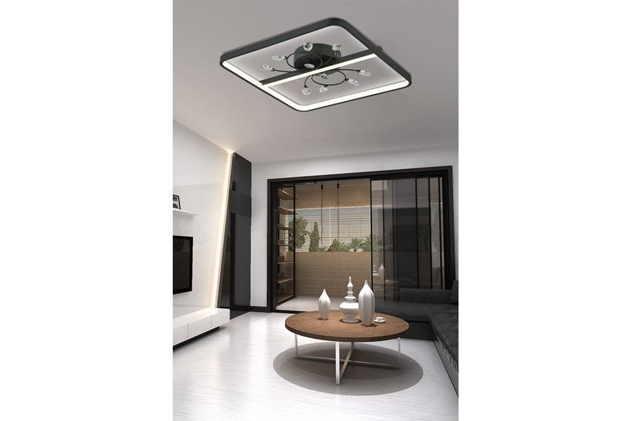 Czarna lampa sufitowa Dacota z jedną diodą LED o mocy 24W, w kształcie kwadratowym z metalowym mocowaniem, zamontowana w nowoczesnym wnętrzu. Widoczny stół z okrągłym blatem oraz dekoracyjne wazony w tle.