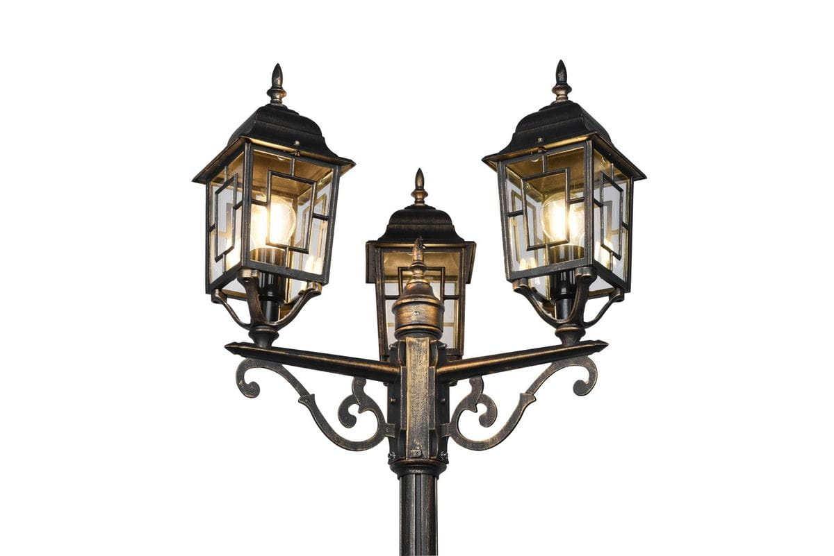 Lampa stojąca ogrodowa Volturno H200 w kolorze antycznej rdzy z trzema kloszami E27. Klosze o prostokątnym kształcie z metalowymi detalami, zamocowane na ozdobnym ramieniu, z widocznymi żarówkami wewnątrz. Ujęcie frontalne.