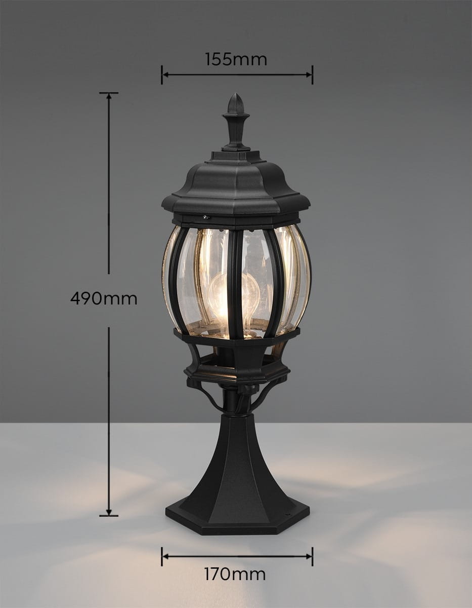 Lampa stojąca ogrodowa Elvo H49 w kolorze czarnym, z kloszem z przezroczystego szkła. Wymiary: wysokość 490 mm, średnica 155 mm, podstawka 170 mm. Kształt okrągły z dekoracyjnym detalem na szczycie. Przeznaczona do żarówki E27.