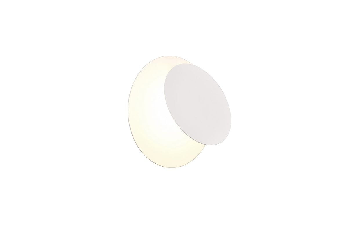 Kinkiet Mio w kolorze białym, z jedną diodą LED o mocy 6W. Okrągła forma z płaską, matową osłoną oraz emitująca ciepłe światło. Produkt zamontowany na ścianie, na jednolitym tle.