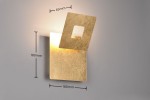 Kinkiet Leano w kolorze złotym, z podświetleniem LED 6W. Ma kwadratowy kształt z otworem w górnej części. Wymiary: 180 mm x 180 mm, grubość 65 mm. Produkt montowany na ścianie, na jasnym tle.