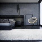 Lampa wisząca Elin w kolorze czarnym, z jednym źródłem światła LED 3W, IP44. Zawieszona w poziomie w nowoczesnym wnętrzu sypialni, obok łóżka, na tle betonowej ściany. Prosty, cylindryczny kształt, minimalistyczny design.