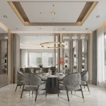 Złota lampa wisząca Aurum D120 z jedną diodą LED, o okrągłym kształcie, zawieszona na cienkich linkach. Widoczna w eleganckiej aranżacji jadalni z szarymi krzesłami i okrągłym stołem, w otoczeniu nowoczesnych mebli.