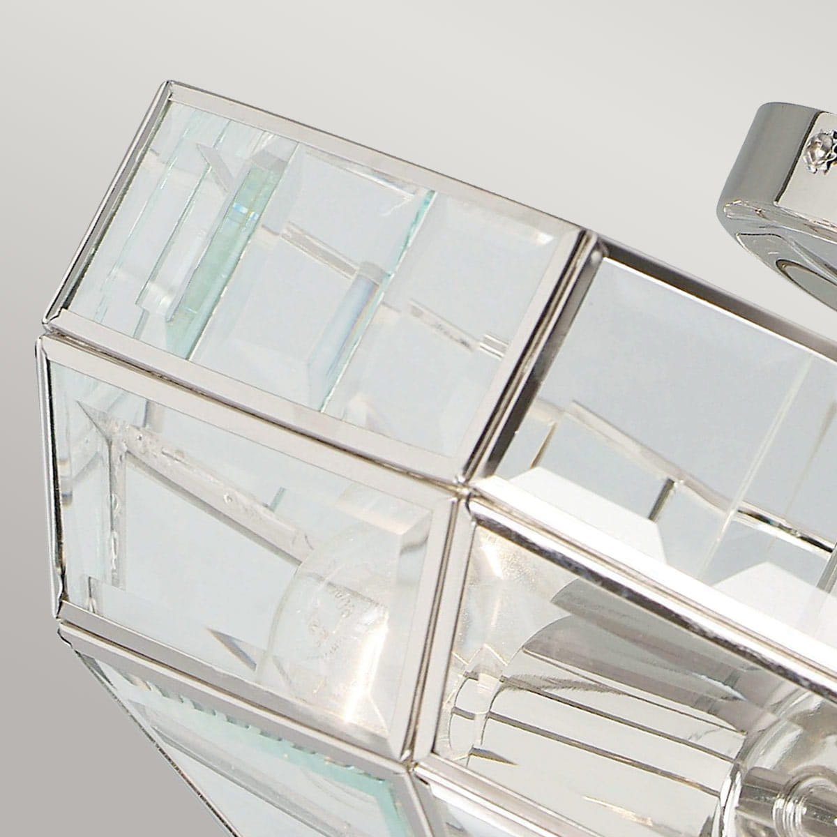Lampa sufitowa Old Park z polerowanego niklu, z dwoma miejscami na żarówki E27. Klosz z przezroczystego szkła o geometrycznym kształcie, z wyraźnymi ściankami i błyszczącymi detalami, prezentująca nowoczesny styl.