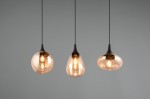 Lampa wisząca Lumina z trzema kloszami w kolorze bursztynowym, zawieszona na czarnych przewodach. Klosze o różnych kształtach: kulistym, łezkowatym i stożkowym, emitują ciepłe światło, tworząc elegancką aranżację. Tło szare, minimalistyczne.