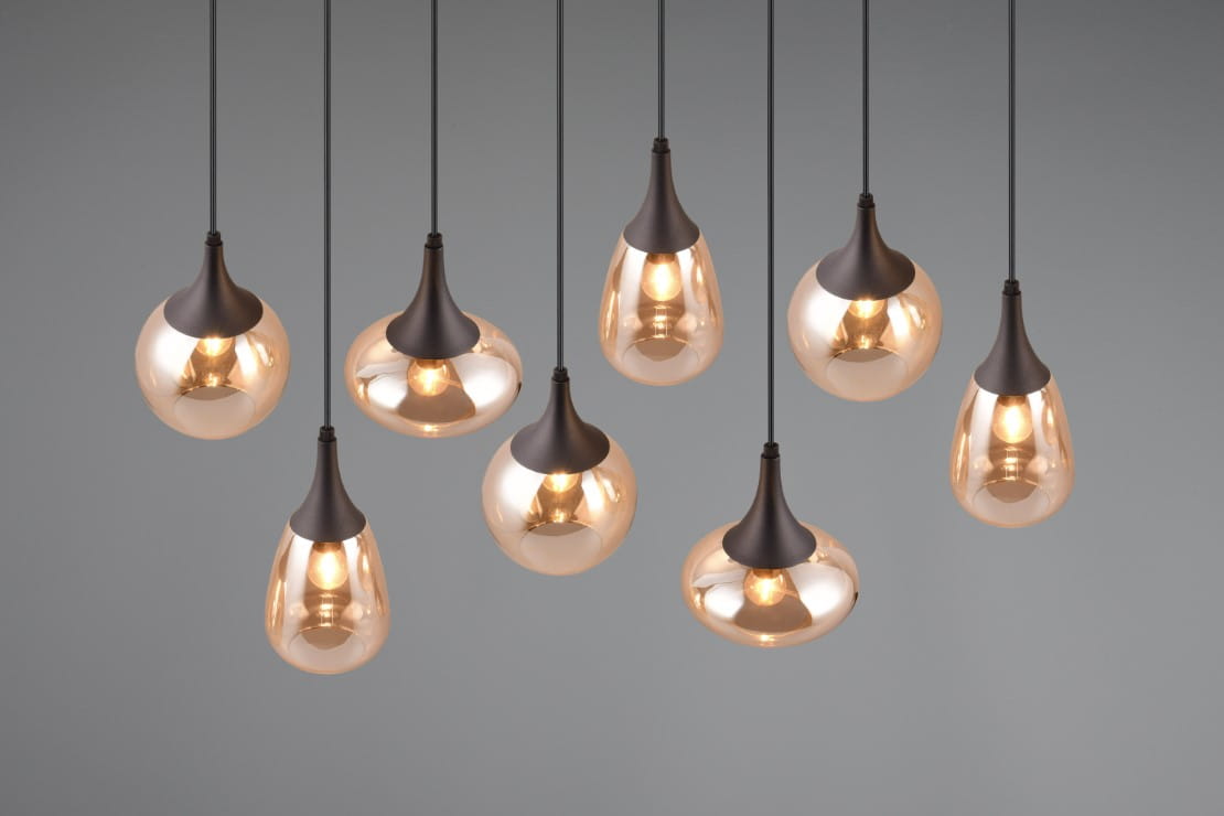 Lampa wisząca Lumina z ośmioma kloszami E14 w kształcie kropli, w czarnym kolorze z bursztynowym szkłem. Klosze zawieszone na cienkich linkach, tworzą asymetryczny układ. Tło szare, podkreślające elegancję lampy.