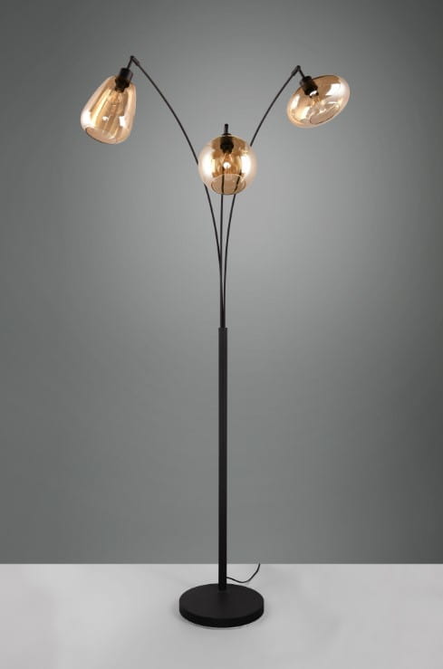 Lampa podłogowa Lumina z trzema kloszami E14 w kolorze czarnym i bursztynowym. Ułożona pionowo, prezentuje elegancki design z zaokrąglonymi kloszami na cienkich ramionach, stojąc na okrągłej podstawie. Tło w odcieniach szarości.
