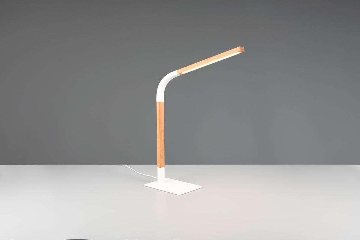 Lampa stołowa Norris z białym korpusem i jasnym drewnianym wykończeniem, z zakrzywionym ramieniem i prostokątną podstawą. Ujęcie frontalne, produkt stoi na jasnym blacie, z widocznym przewodem zasilającym. Idealna do nowoczesnych wnętrz.
