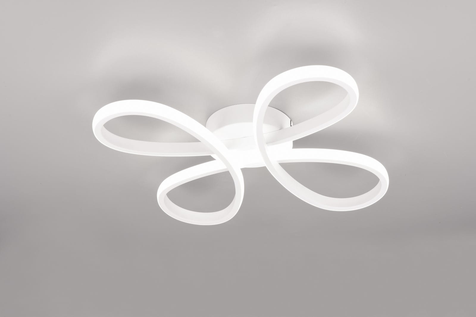 Lampa sufitowa Fly z białym, elastycznym designem, składająca się z czterech falujących ramion. Ujęcie z dołu, na jednolitym tle. Wbudowane źródło LED o mocy 22W, barwa światła 4000K. Montaż sufitowy, minimalistyczny styl.