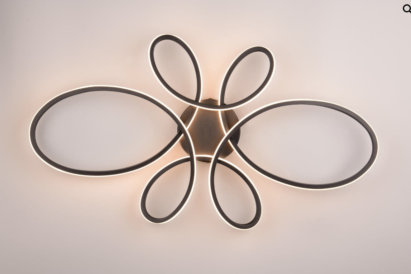 Lampa sufitowa Fly w kolorze czarnym, z LED o mocy 32W i temperaturze barwowej 3000K. Posiada unikalny kształt złożony z owalnych ramion, które emitują ciepłe światło. Ujęcie frontalne, montaż sufitowy.