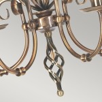 Żyrandol Artisan 5xE14 w postarzanym mosiądzu, z eleganckimi, zakręconymi detalami. Widoczny centralny element z metalowym, zwężającym się wzorem oraz gładkie ramiona, które przypominają klasyczny styl.
