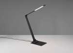 Lampka biurkowa Travis w kolorze czarnym, z regulowanym ramieniem, z wbudowanym portem USB-C. Kąt ujęcia z boku, na jednolitym tle. Widoczna podstawa oraz źródło światła LED o mocy 6,5W.