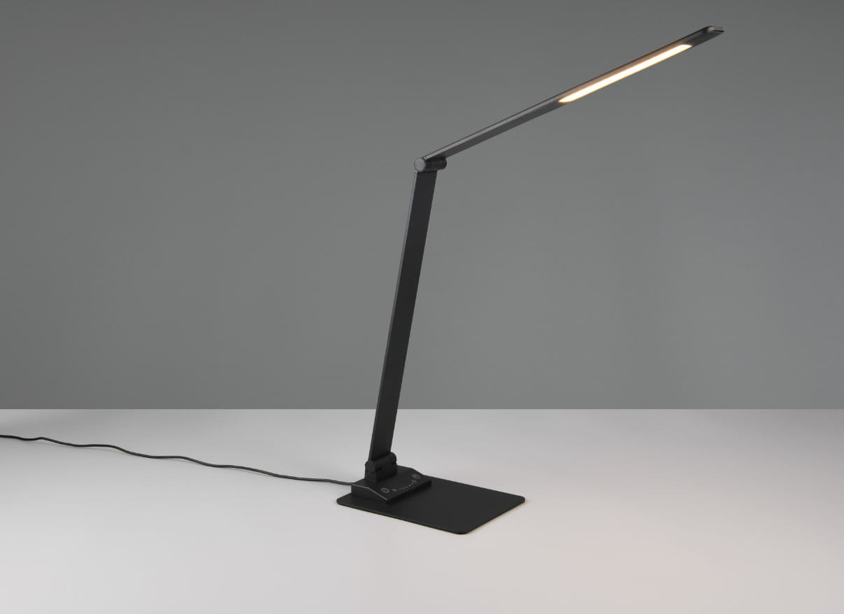 Lampka biurkowa Travis w kolorze czarnym z portem USB-C, wykonana z metalu, z prostokątnym kloszem LED o mocy 6,5W. Ujęcie z boku, stojąca na płaskiej podstawie, z widocznym kablem zasilającym. Tło jednolite, szare.
